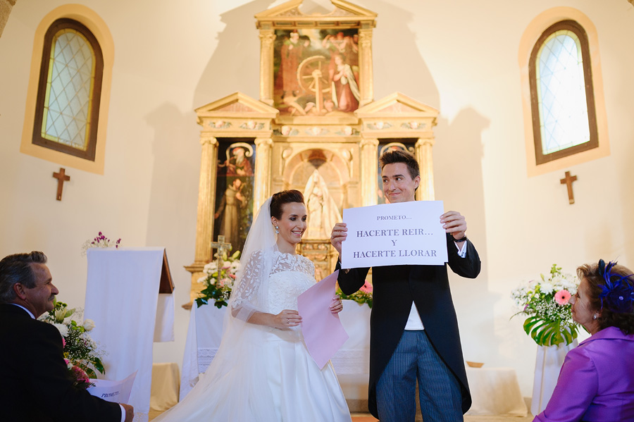 novios en el cartel muestran carteles de papel con mensajes del uno hacia el otro en forma de votos matrimoniales